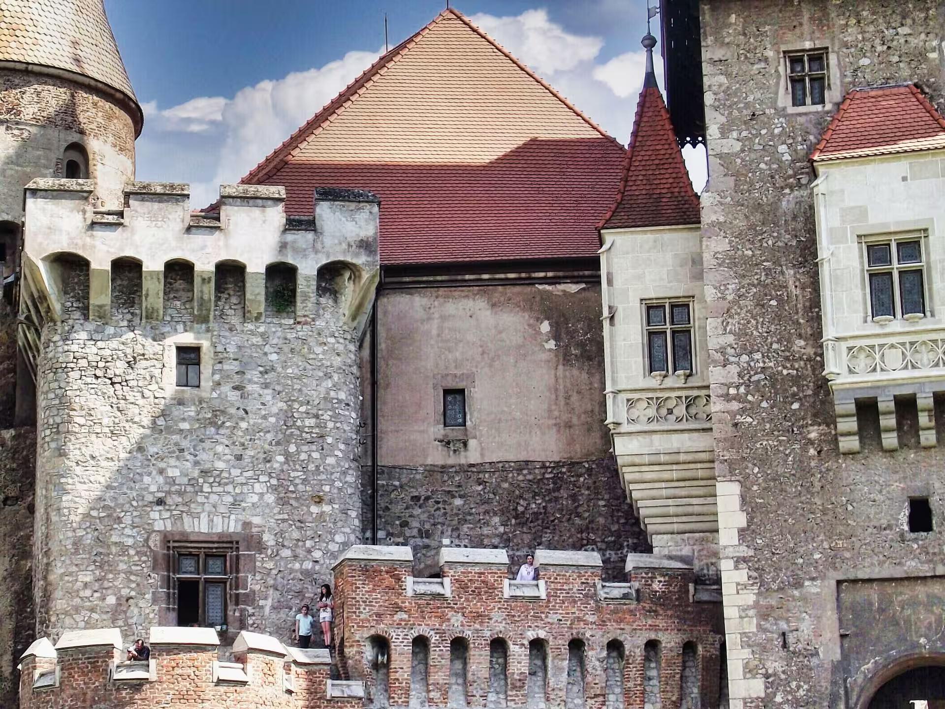 Close-up of Corvin Castle courtyard walls and red-roofed towers during a guided day tour from Cluj Romania