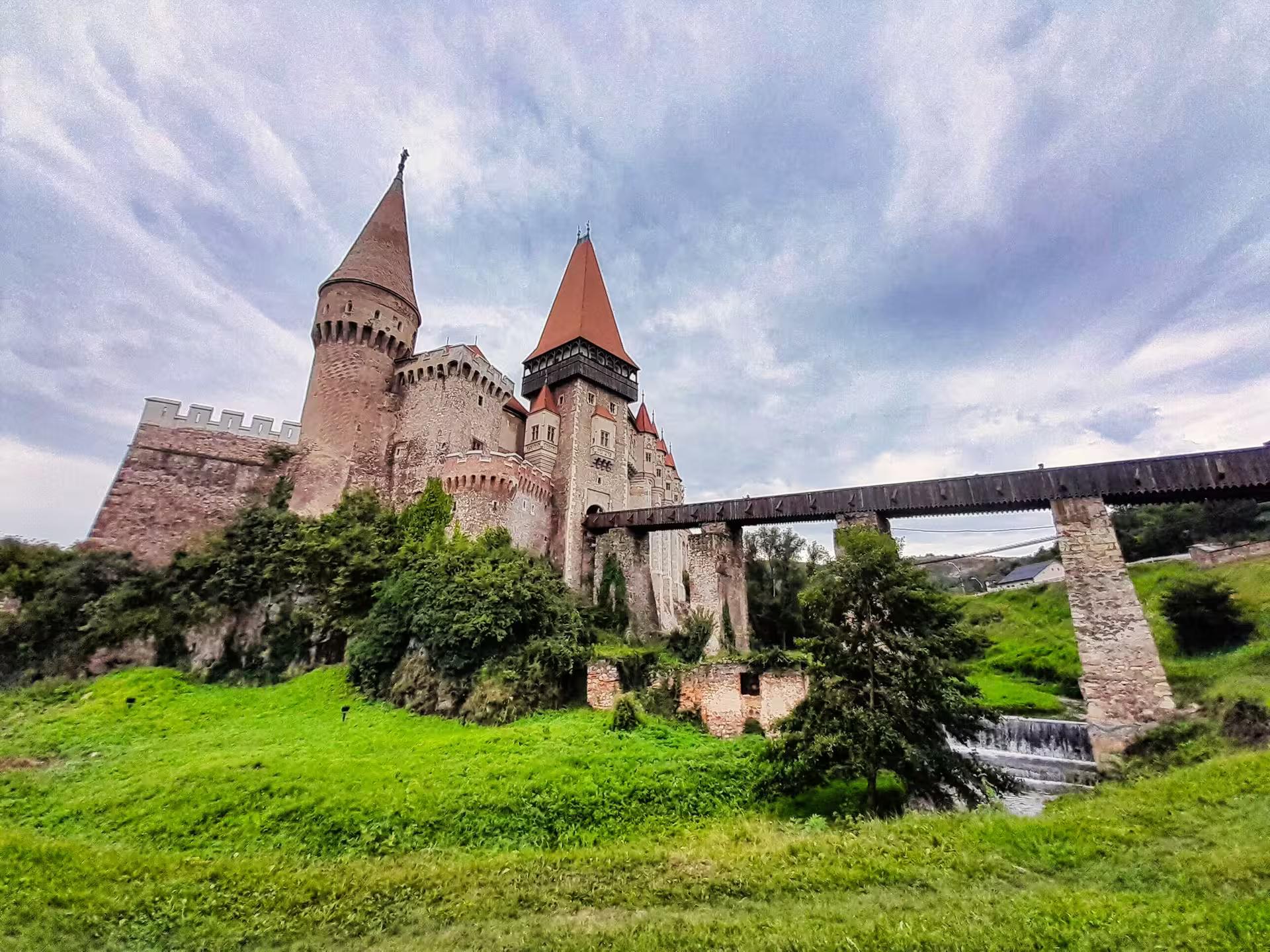 Stunning exterior view of Corvin Castle with medieval towers and wooden bridge on a guided tour from Cluj
