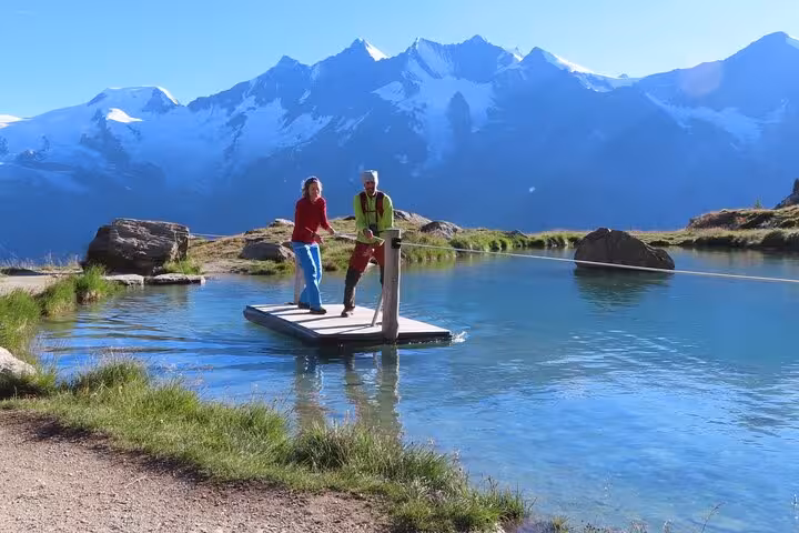 Couple on a small lake raft with alpine peaks, scenic Swiss Alps tour from Zurich Airport to Jungfrau region