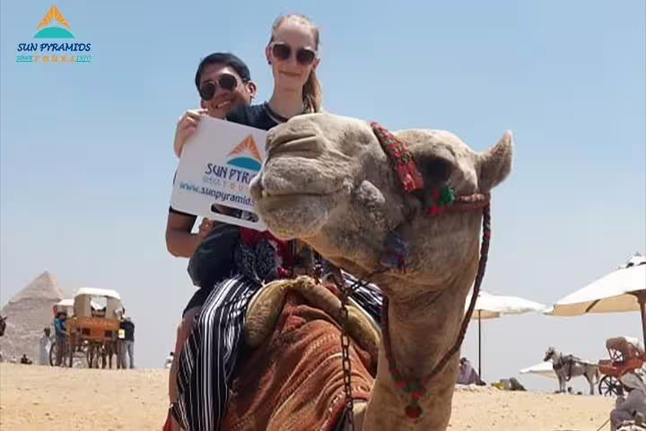 Couple riding camel near Giza Pyramids, private 2-hour camel tour with desert views and photo stop