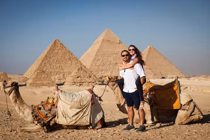Couple with camels at Giza Pyramids on Hurghada to Cairo day trip, perfect first-time Egypt tour