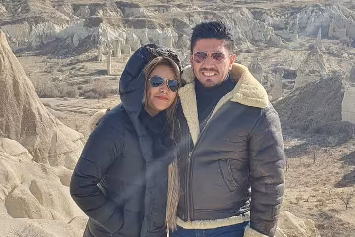 Couple posing in Cappadocia fairy chimneys on private tour with English speaking guide and luxury car