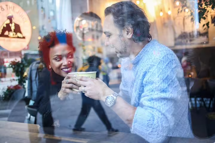 Couple enjoys coffee date through a window reflection during private New York photography tour.