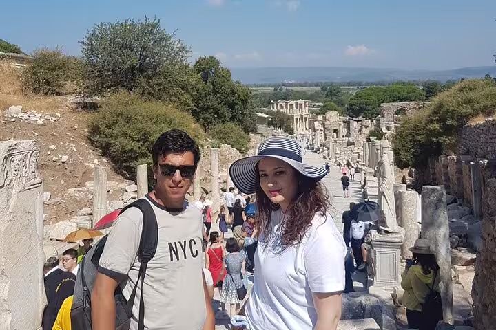 Couple on Curetes Street in Ephesus, Turkey, during Izmir cruise port tour with ruins and crowds behind
