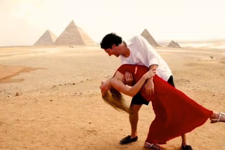 Couple dancing in the desert with the Giza Pyramids backdrop on an Alexandria Port day trip to Cairo and GEM