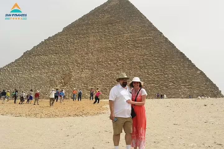 Couple posing by the Great Pyramid of Giza during Cairo excursion on 8-day Luxor Nile cruise and Cairo tour