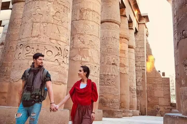 Couple walking among carved columns at Karnak Temple on a private Luxor day tour from Safaga Port