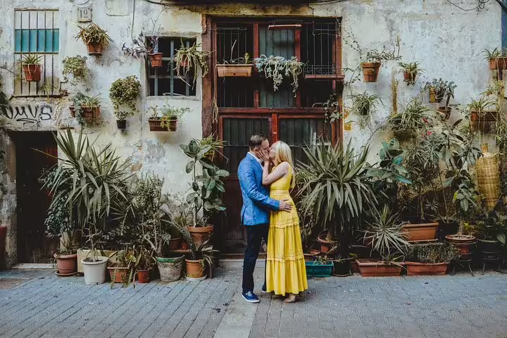 Couple kissing in a plant-filled Barcelona courtyard on a private personal travel photographer photo tour