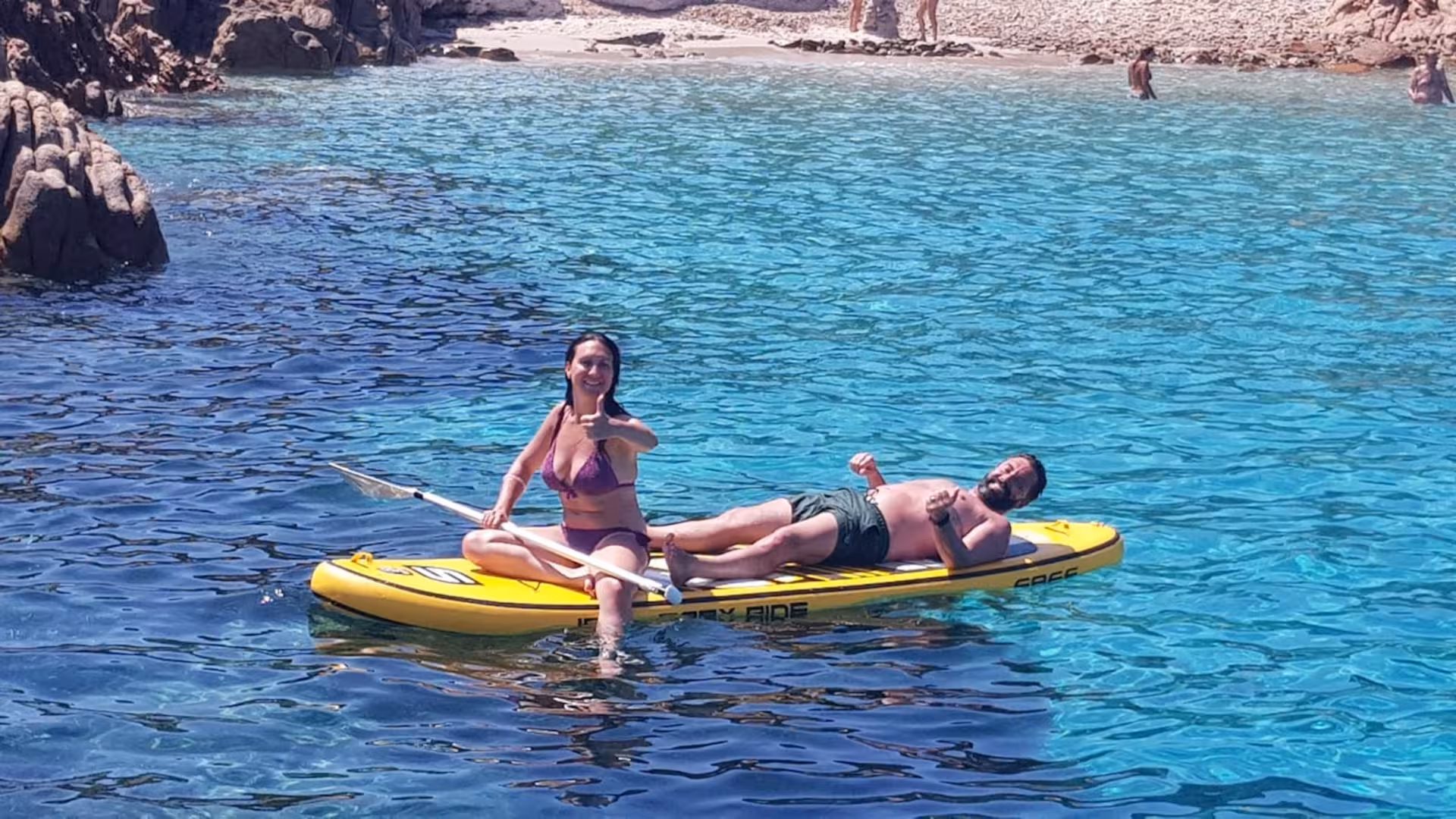 Couple on a paddleboard in the turquoise waters of La Maddalena Archipelago, enjoying a scenic speedboat tour.
