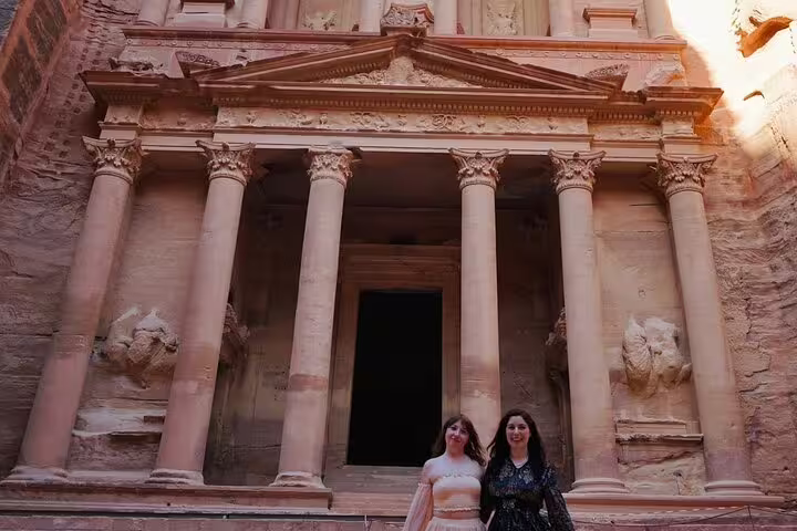 Couple posing at Petra Treasury facade, must-see Jordan stop on 13-day Egypt Jordan landmarks tour with Cairo to Amman flight