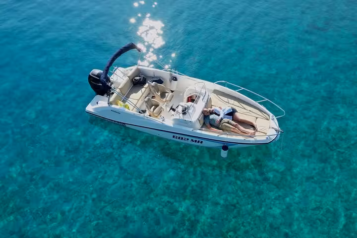 Couple relaxing on a private speedboat over clear Adriatic Sea, Croatia boat tour with snorkeling stop