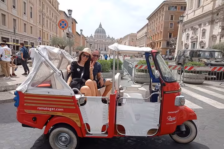 Couple enjoying a romantic buggy tour in Rome with a view of St. Peter's Basilica in the background.