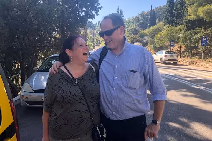 Couple laughing roadside during a Rome to Pisa day trip, relaxing on a full-day Tuscany and Pisa tour