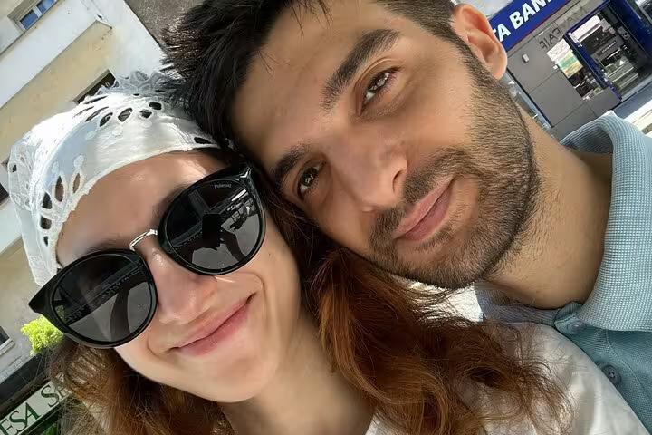 Couple taking a selfie outdoors near a bank in Bucharest city center