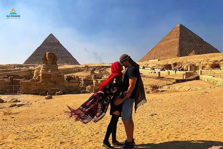 Couple at the Sphinx with Giza pyramids backdrop on a Cairo half-day horse carriage tour experience