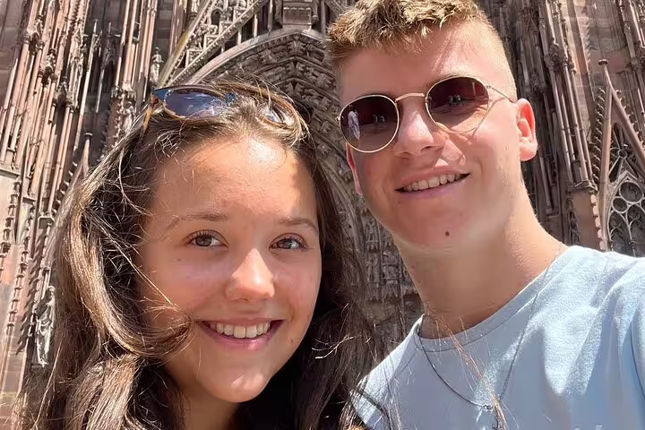 Couple selfie in front of Strasbourg Cathedral façade on a Strasbourg scavenger hunt and highlights walking tour
