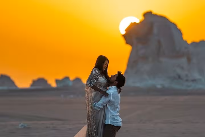 Couple at sunset with White Desert limestone monoliths in Bahariya on a 2-day private White & Black Desert tour