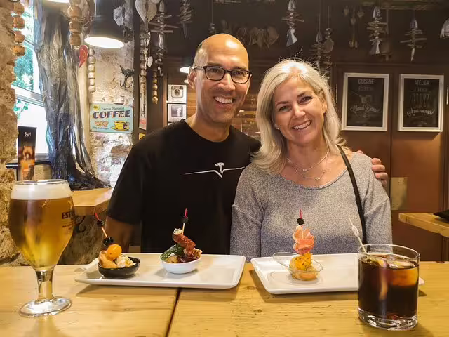 Couple enjoying tapas and drinks in a cozy Barcelona tavern during a food and drink private tour.