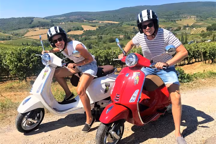 Couple enjoying a Tuscany Vespa tour with scenic vineyard views near Florence, perfect for a small-group adventure.