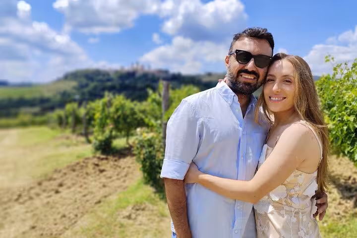 Couple enjoying the scenic vineyards of Tuscany under a blue sky on a wine tour from Florence.
