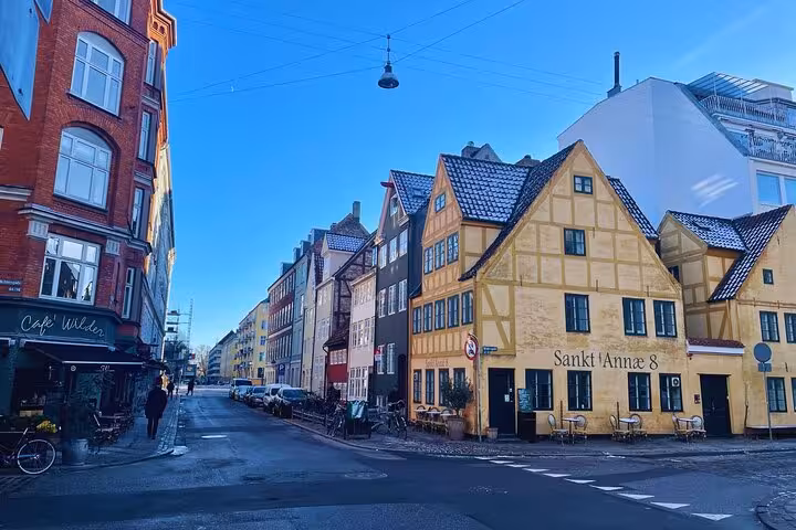 Charming European street with colorful historic buildings on a sunny day, ideal for cultural walking tours.