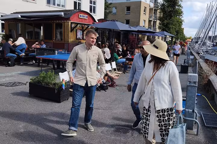 Visitors strolling along a vibrant waterfront café area during the small group walking tour with cultural insights.