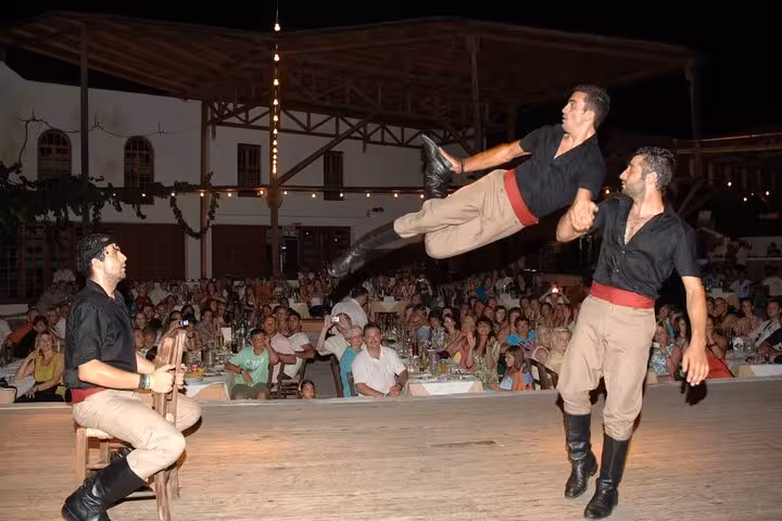 Live Cretan night performance with acrobatic folk dancers on stage, traditional music, dinner and dancing show