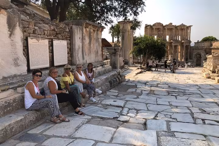 Cruise guests resting on ancient marble street in Ephesus near Kusadasi Port on private guided tour