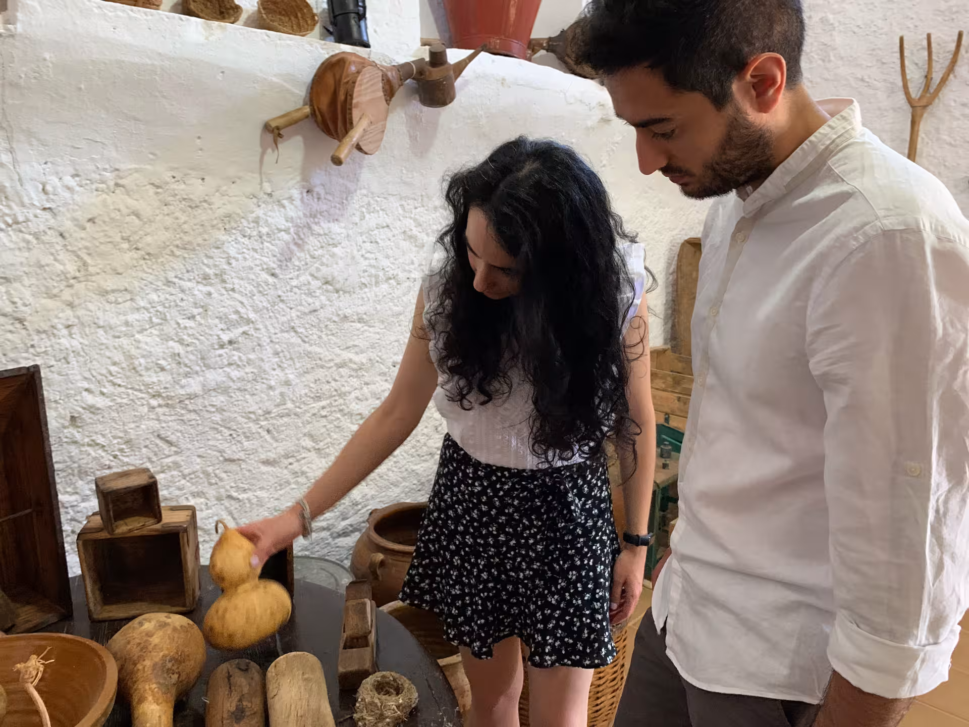 Visitors exploring traditional tools and artifacts in a cultural heritage museum.