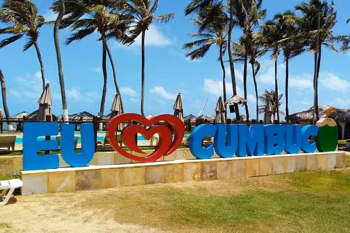 EU ❤️ Cumbuco sign with palm trees and beach huts, iconic photo stop on Cumbuco Beach tour from Fortaleza
