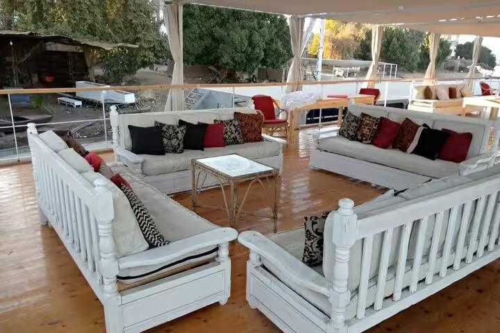 Open-air lounge deck on Dahabiya Nile cruise with cushioned sofas, relaxing on 5 days 4 nights itinerary