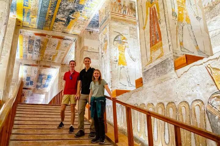 Travelers in a decorated pharaohs tomb corridor, a highlight stop on a 5 days 4 nights Dahabiya Nile cruise