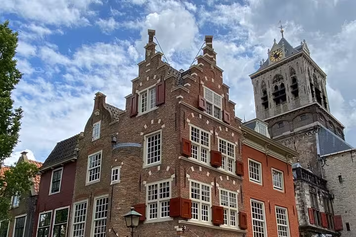 Historic Delft canal houses and Nieuwe Kerk tower, stop on private tour from Rotterdam to Kinderdijk and The Hague