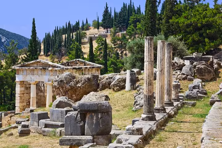 Ancient Delphi ruins with stone columns and treasuries on hillside, part of 2-day Delphi and Meteora private tour