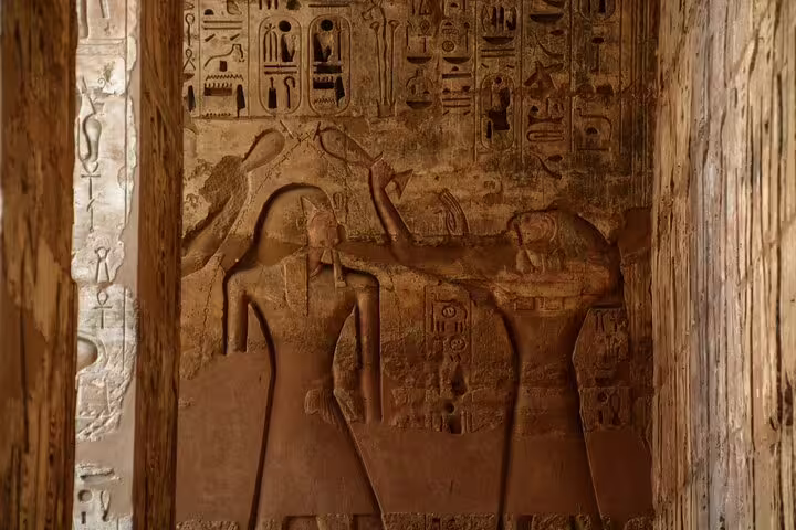 Ancient carved relief and hieroglyphs inside Medinet Habu temple, Luxor West Bank day tour