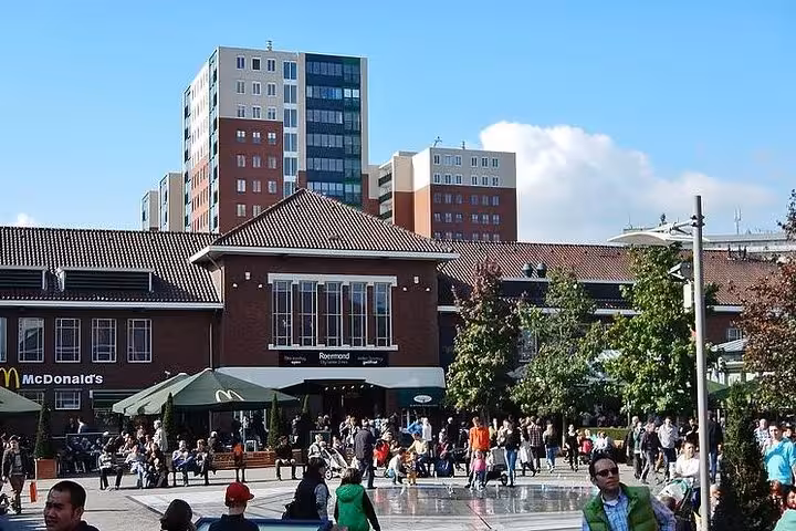 Busy plaza at Designer Outlet Roermond with cafes and crowds, popular stop on private Amsterdam shopping tour