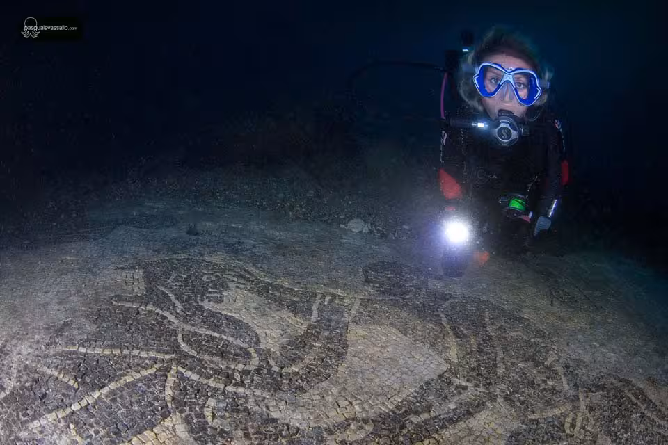 Diver swimming near the black and white mosaic from the "Villa a Protiro" site, called the "Wrestlers" mosaic.