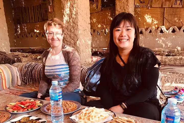 Tourists enjoy Bedouin lunch in Bahariya Oasis on 5-day Djara Cave, Black and White Desert camping package