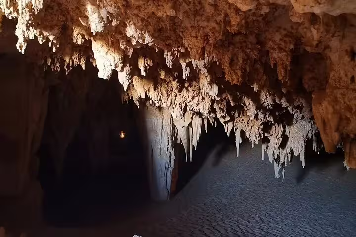 Djara Cave interior with limestone stalactites and sandy floor, highlight of Egypt desert adventure tour