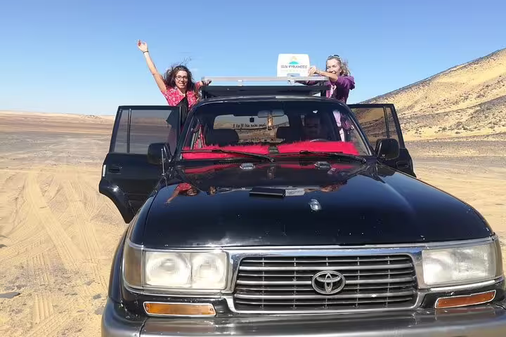 Tourists in 4x4 jeep crossing Sahara on 5-day Djara Cave, Black and White Desert camping adventure