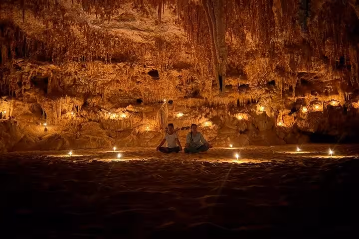 Candlelit Djara Cave chamber with stalactites, part of 3-day White Desert and Black Desert camping tour