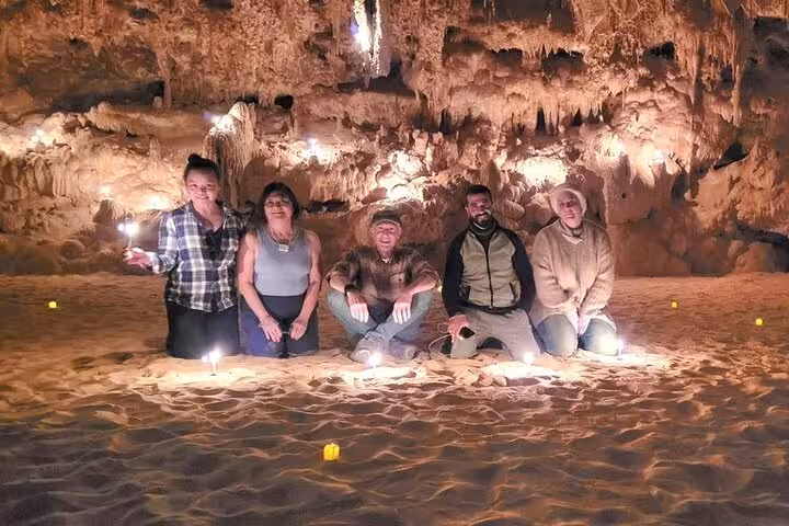 Travelers posing in illuminated Djara Cave on 3-day White Desert Black Desert desert camping adventure in Egypt