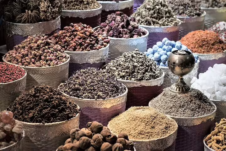 A vibrant display of spices and herbs in woven baskets at Souq Waqif, showcasing Doha's rich culinary heritage.