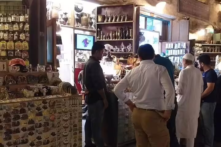 Visitors explore a vibrant shop filled with traditional crafts and souvenirs in Doha's bustling markets, capturing local culture.