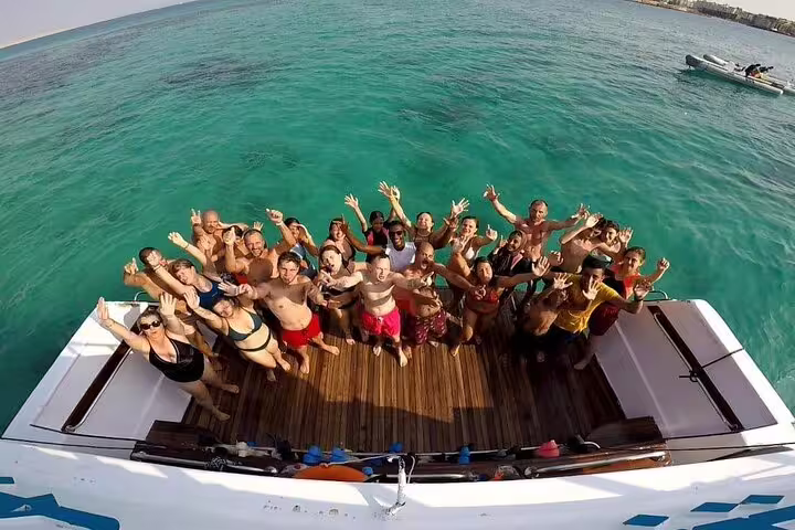 Guests waving on VIP boat deck in turquoise Red Sea during Hurghada Dolphin House snorkeling day trip