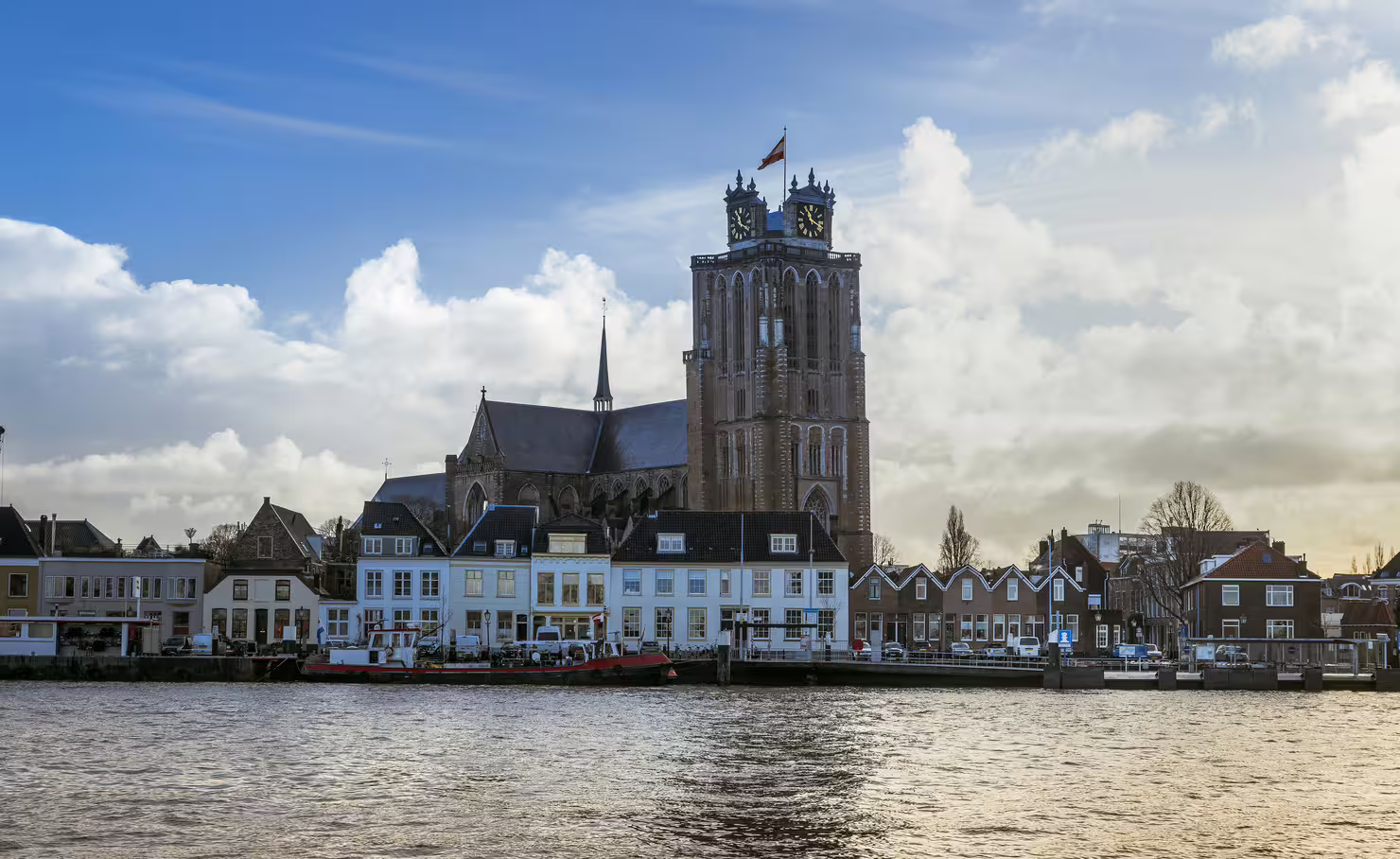 Grote Kerk clock tower and waterfront skyline in Dordrecht, Netherlands, on a self-guided audio walking tour