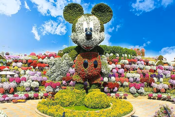 Dubai Miracle Garden entry ticket view of giant Mickey-shaped floral sculpture amid colorful flower beds