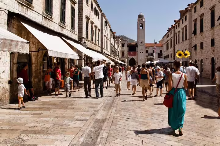 Stradun street scene in Dubrovnik Old Town with clock tower, featured on a private walking tour