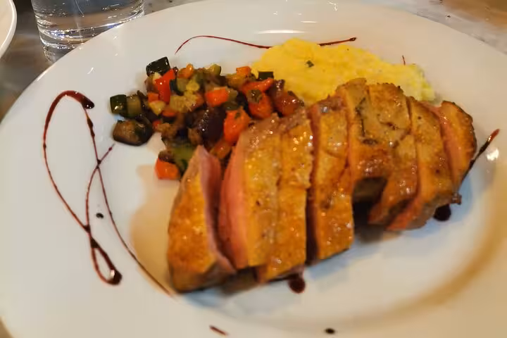 Plated duck breast with ratatouille and creamy polenta, made during Avignon cooking workshop with chef