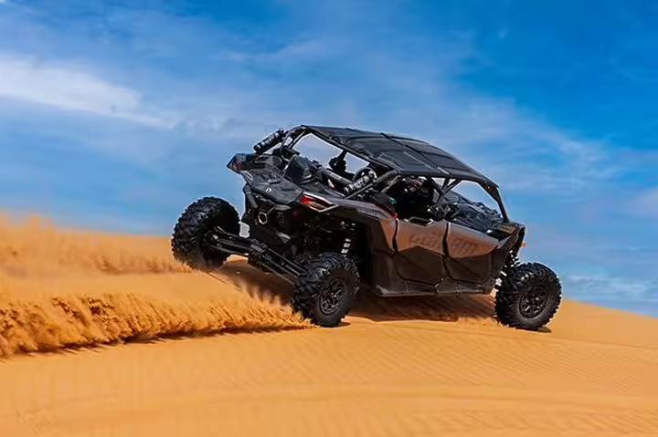 Dune buggy racing through golden sands under a clear blue sky in Dubai, perfect for an adventurous desert quad bike rental experience.